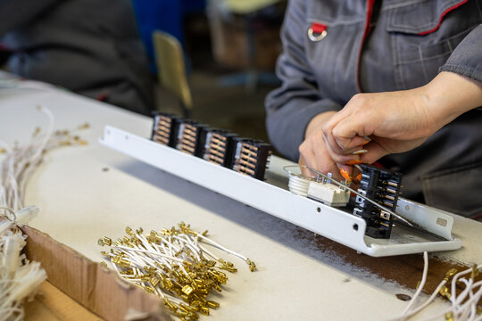 Factory worker assembling electrical components with precision