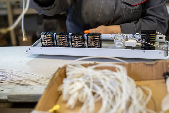 Factory worker assembling electrical components on production line