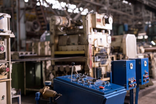 Industrial factory control panel with machinery in background