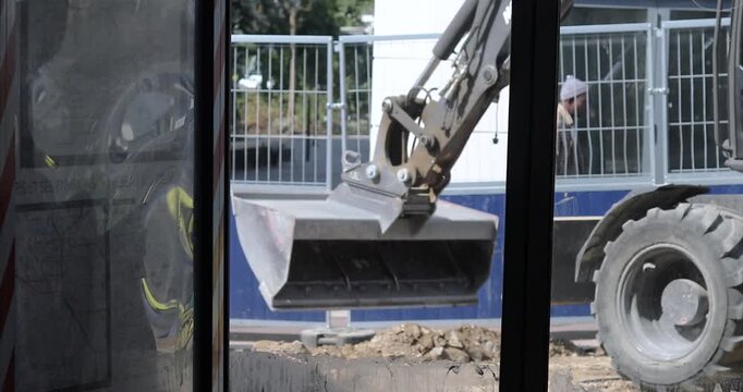 A view from the window of an excavator bucket leveling the surface for paving