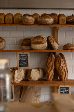 hip Portugese bakery selling fresh baked bread loaves, white tile, chalk signage, and minimal wooden shelves