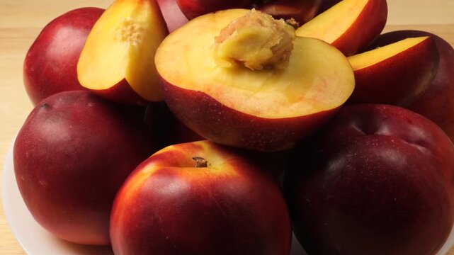 Ripe and juicy nectarines rotating on a plate