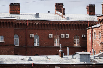 Historic red brick building with modern AC units and roof. High quality photo. © MyJuly
