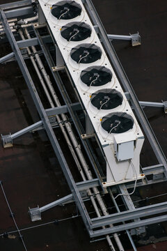 Industrial row of AC units on metal rooftop frame. Top view, technology.