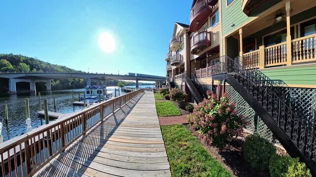 Moving camera captures riverside residential boardwalk centered on waterfront boardwalk in Occoquan Virginia.
