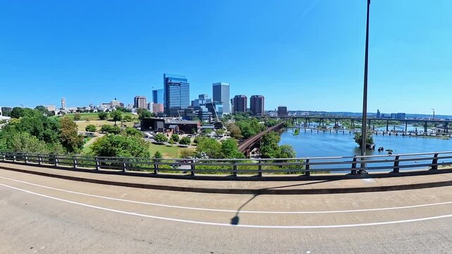 Moving camera captures urban river panorama centered on richmond skyline in Richmond Virginia.
