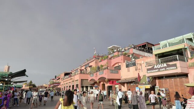 Marrakech, morocco. August 9, 2026. Bustling street scene in the vibrant jemaa el fnaa square in marrakech, morocco, with tourists and locals walking among the buildings