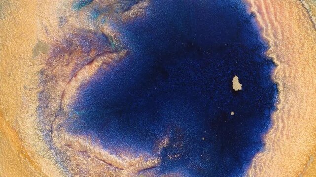 Mixing alcohol ink in macro view with shimmering effect on the surface