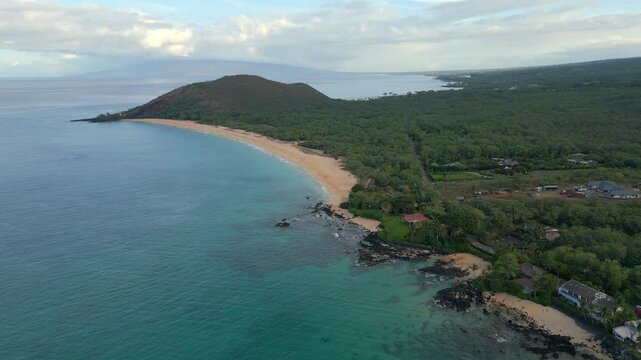 Aerial over Ahihi Bay, Makena Beach and Makena Cove in Kihei, on the island of Maui in Hawaii. Puʻu Olai crater with west Maui visible in the distance during early morning, empty beach.