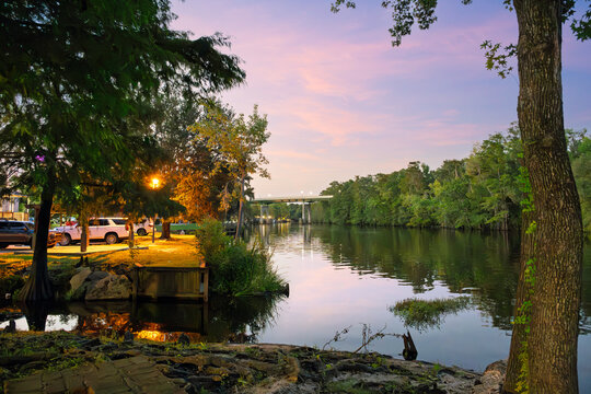 Early evening view from the Conway Riverwalk pedestrian boardwalk along the Waccamaw River, with the illuminated Memorial Bridge in view, in Conway, South Carolina, in the Southeast USA.