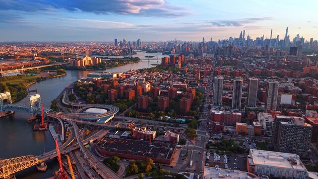 Panoramic view of a bustling city cityscape during late afternoon or sunset. Drone flight over East Harlem in Manhattan and the South Bronx, divided by the Harlem River.