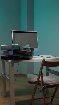 Vertical video employee carrying a stack of business folders and documents while working overtime in a dark office, dedicating extra hours to complete important tasks