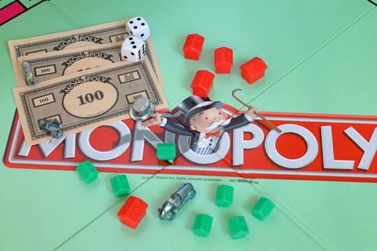 Monopoly board game. Fun for the whole family. Finnish text. Business and estate concept. Mix of different pieces and money.