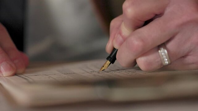 1930's businessman writing in a ledger using a fountain pen