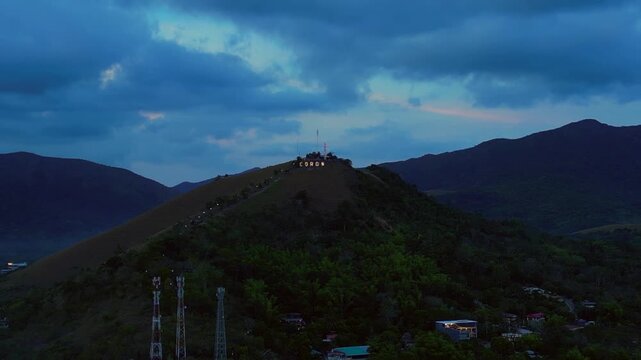 Coron town sign illuminating Mount Tapyas at dusk. Magic aerial view drone