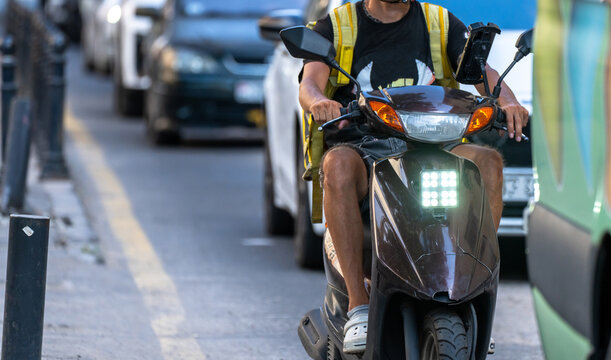 A courier delivers food on a moped