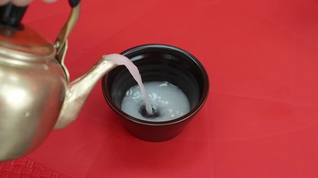 Close-up Fixed Shot of Pouring Traditional Korean Rice Wine Makgeolli into a Bowl (Korean Culture, Beverage)