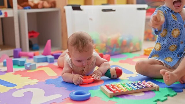 Two hispanic brothers playing on a colorful foam mat, baby chewing teether near xylophone in playroom building; joy sibling bonding.