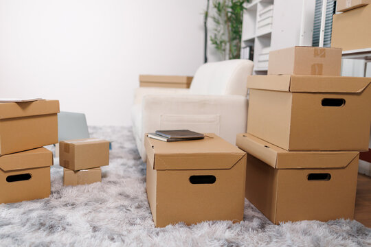 Cardboard moving boxes filling a new living room, representing a seamless relocation, home delivery, and the exciting start of a new chapter in life