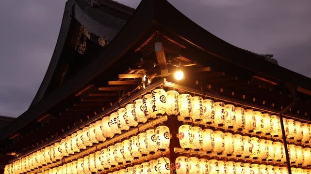 Illuminated exterior of Yasaka Shrine at night, with long rows of glowing lanterns tracing the traditional roofline and creating a warm golden atmosphere in Kyoto&rsquo;s Gion district