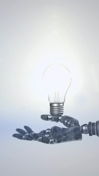 Animation of illuminated light bulb over hand of robot arm, with blue light on grey background