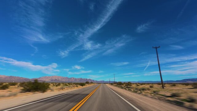 Mojave Desert POV Drive Past Utility Poles and Distant Mountains