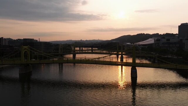 Roberto Clemente Bridge crossing Allegheny River at sunset in Pittsburgh, aerial