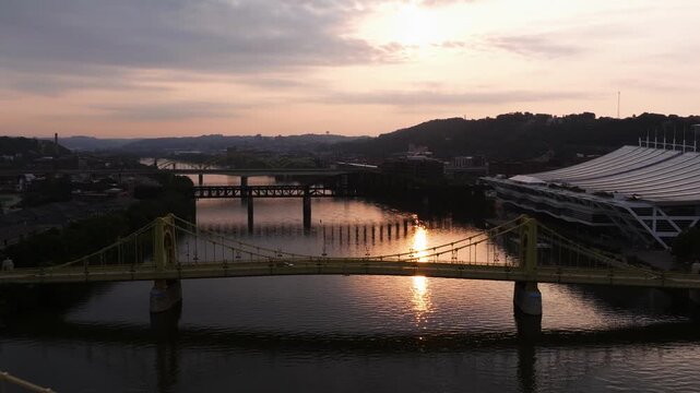 Roberto Clemente Bridge by downtown Pittsburgh and convention center at sunset, aerial backdrop
