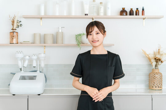 美容サロンで笑顔で迎えるエステティシャンの若い女性スタッフ