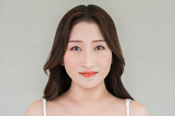 Fototapeta premium Beauty portrait of a woman (in her 40s or 50s) with clear, radiant skin gazing straight ahead.