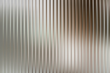 Vertical metallic ribbed texture with soft gradient light reflections © QBeStock