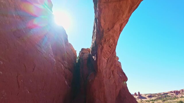 Warm sunset light illuminates the natural sandstone alcove span of Tapestry Arch along the Broken Arch loop in Arches National Park Utah