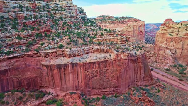 Vast red rock walls and sandstone cliffs tower over Grand Wash canyon along the Cassidy Arch trail in Capitol Reef National Park Utah