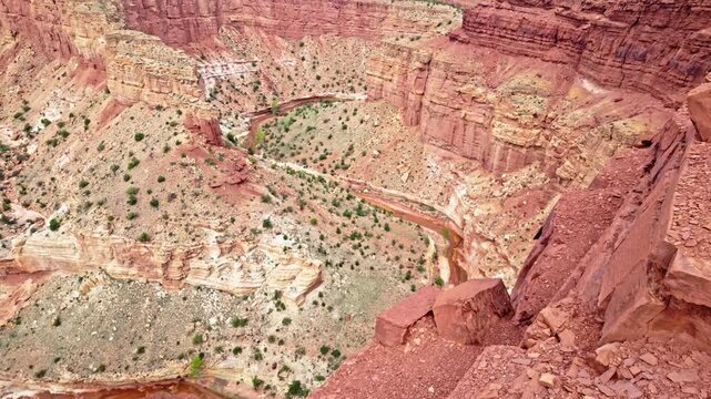 Deep carved canyon chasm drops dramatically below Goosenecks Overlook in Capitol Reef National Park Utah