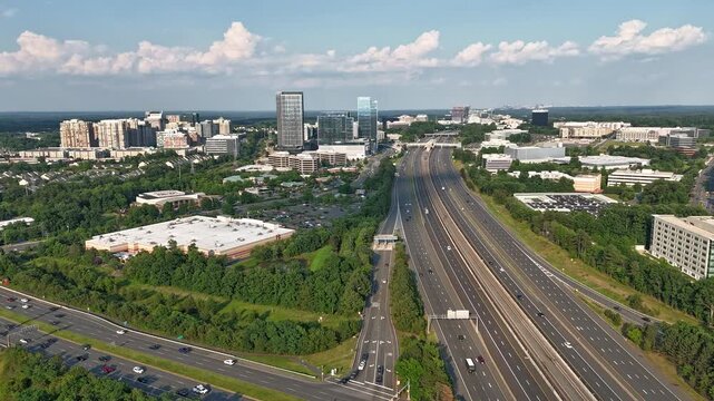 Aerial drone hyperlapse of multi-lane highway traffic and modern commercial skyline in Reston, Northern Virginia, showcasing suburban infrastructure, real estate, and economic growth.
