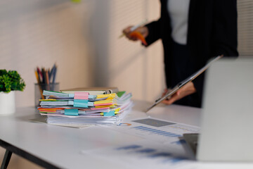 Professional business person organizing paperwork and managing files on an office desk, reviewing...
