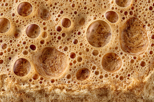 Macro closeup of baked bread crust texture with detailed air bubbles and pores