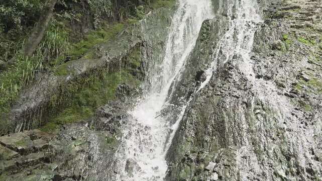 Water splashes over textured rock at Yeddi Gozel Waterfall in Gabala in a close daylight view.