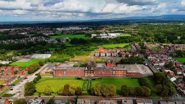 Aerial flyover shot of a historic red brick building in Fulwood, Preston