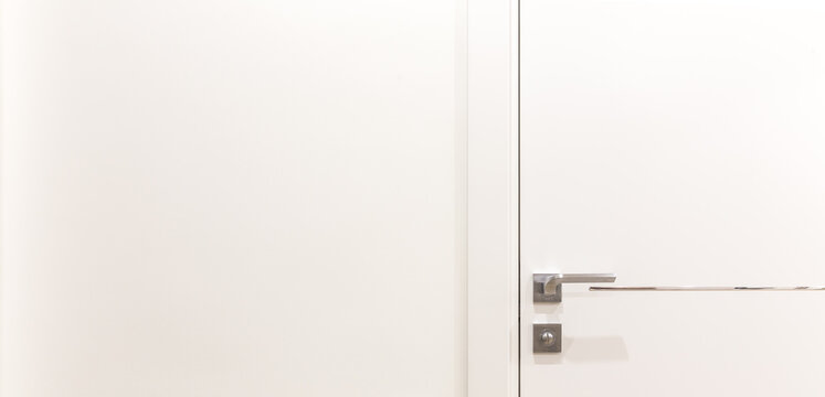 Metalic doorknob on a white modern door