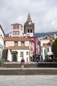 Tourist in the city, Small square in the old town with colourful houses and chapel Capela de Santo Antonio de Mouraria, in the back tower of the church S&eacute; do Funchal, Funchal, Madeira, Portugal