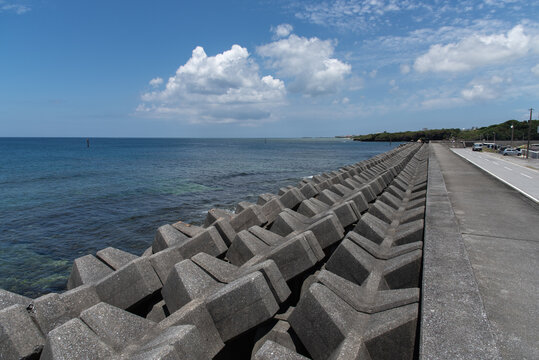 快晴の空と消波ブロックのある水平線のはっきりした防波堤の海岸