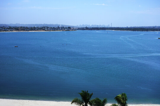 High-angle view of deep blue water in Mission Bay with the San Diego city skyline visible in the distance, Southern California in summer