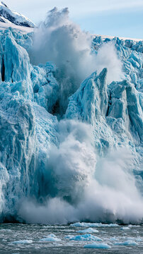 Glacier Calving in Arctic Ocean: A colossal glacier dramatically calves into the frigid waters of the Arctic Ocean, sending massive chunks of ice crashing down in a powerful display of nature's force.