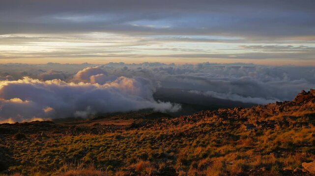 Day to night sunset view above the clouds from Kalahaku Overlook in Haleakalā National Park, on the Haleakala volcano located on Maui, Hawaii. East Maui Volcano. Shot in time-lapse over an hour.