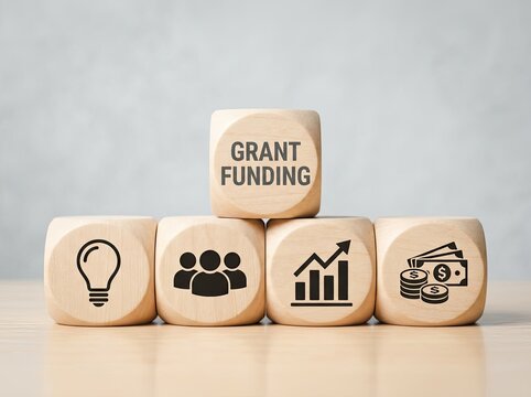 Wooden cubes showing grant funding text and business icons ideal for financial media symbolizing project support and economic growth