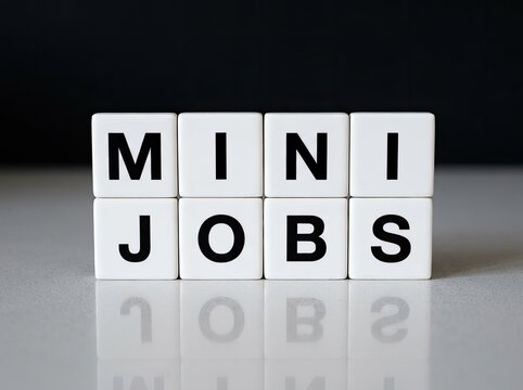 White cubes spelling MINI JOBS on reflective surface ideal for employment media symbolizing flexible work gig economy and side income
