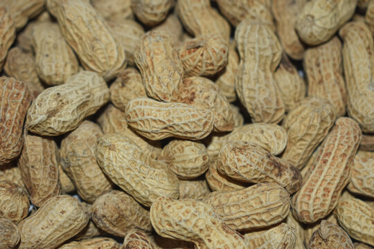 Pile of whole raw peanuts in shell macro close up