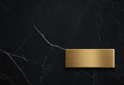 Blank gold nameplate on dark black marble background for luxury branding and corporate signage
