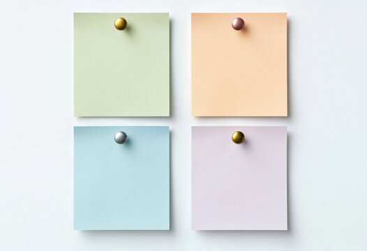 Four pastel memo cards pinned on a white board for office notes and creative planning
